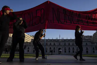 El grupo feminista 8M se manifiesta en contra de una posible votación en el Senado sobre una ley de seguridad frente al palacio presidencial de La Moneda en Santiago de Chile, el martes 4 de abril de 2023. (AP Foto/Esteban Felix)