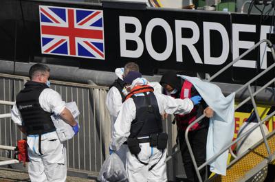 Personas que se cree son migrantes desembarcan el jueves 16 de septiembre de 2021 de un barco patrulla de la Fuerza Fronteriza Británica en el puerto de Dover, Inglaterra, después de que los rescataran de una lancha inflable en el canal de la Mancha. (AP Foto/Alastair Grant)