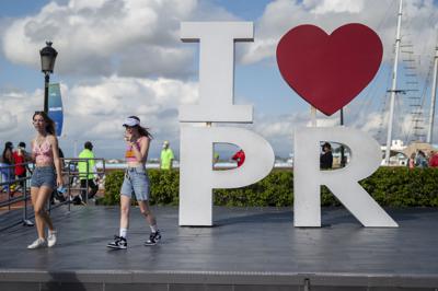 Turistas caminan por el puerto tras desembarcar del crucero Carnival Mardi Gras, en San Juan, Puerto Rico, el 3 de agosto de 2021, el primero en atracar en el territorio estadounidense desde el inicio de la pandemia. (AP Foto/Carlos Giusti)