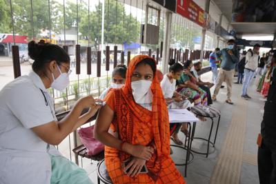 Una trabajadora de la salud administra una dosis de la vacuna contra el COVID-19 durante una campaña especial de vacunación impulsada por la municipalía, en una parada de bus en Ahmedabad, India, el 17 de septiembre de 2021. (AP Foto/Ajit Solanki)
