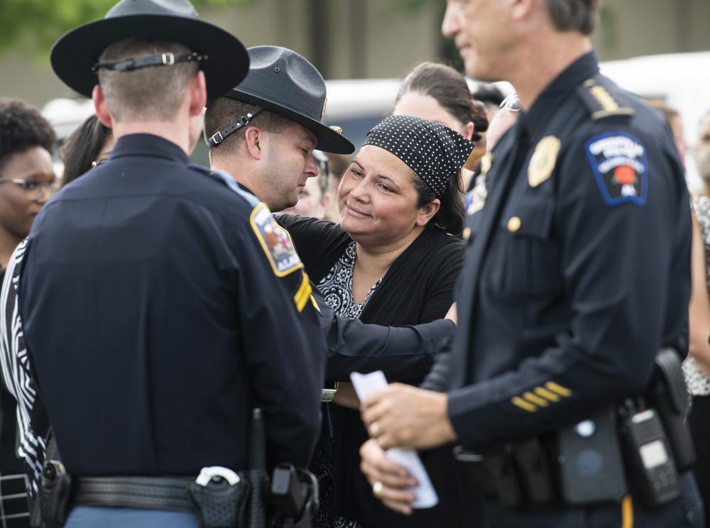 Candice Gulley is greeted by Alabama State Troopers following a prayer vigil for the eight Alabama children that died in a June 19 crash on I-65 at Church of the Highlands in Auburn, Ala., on Thursday, July 15, 2021. Gulley was the sole survivor of a passenger van that crashed June 19 that killed eight Alabama children including two of her own. (Jake Crandall/The Montgomery Advertiser via AP)