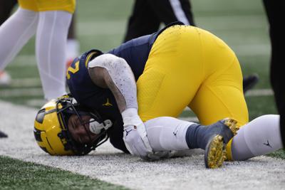 No. 3 Michigan's RB Corum hurts knee, limited vs. Illinois | AP News