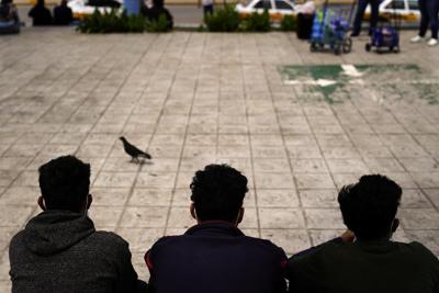 ARCHIVO - En esta foto de archivo del 13 de mayo de 2021, migrantes hondureños se sientan en una plaza en la frontera después de ser devueltos de Estados Unidos a México, en Reynosa, México. (AP Foto/Gregory Bull, Archivo)