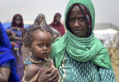 Una mujer y un niño esperan a que el Programa Mundial de Alimentos (PMA) distribuya alimentos en la región de Afar, Etiopía, el lunes 30 de agosto de 2021 (Claire Nevill/WFP vía AP).