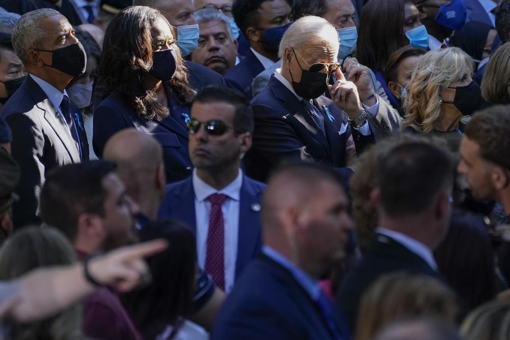 Al fondo, de izquierda a derecha, el expresidente Barack Obama, la ex primera dama Michelle Obama, el presidente de Estados Unidos, Joe Biden, y la primera dama Jill Biden asisten a una ceremonia por el vigésimo aniversario de los ataques terroristas del 11 de septiembre de 2001, en el monumento nacional conmemorativo del 11-S en Nueva York, el sábado 11 de septiembre de 2021. (AP Foto/Evan Vucci)