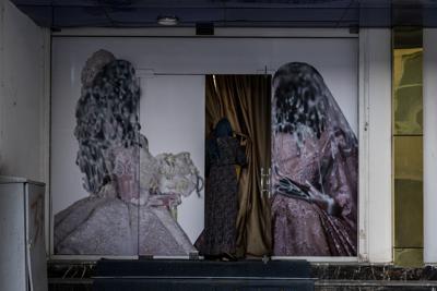 Una mujer ingresa en un salón de belleza en Kabul, Afganistán, el sábado 11 de septiembre de 2021. Desde que los talibanes asumieron el control del gobierno, diversas imágenes sobre mujeres en el exterior de salones de belleza fueron retirados o cubiertos. (AP Foto/Bernat Armangue)