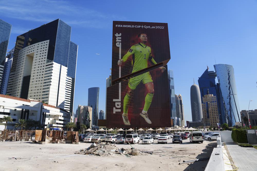 Un solar en construcción, delante de un edificio con un cartel con la imagen del portero de Alemania Manuel Neuer, en el centro de Lusail, Qatar, el 24 de noviembre de 2022. (AP Foto/Pavel Golovkin)