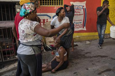 Una mujer afectada por gas lacrimógeno después de unas protestas en Puerto Príncipe el 27 de septiembre del 2021. El reciente secuestro masivo de misioneros extranjeros revela cómo ha aumentado el poder de las pandillas en Haití. (AP foto/Rodrigo Abd)