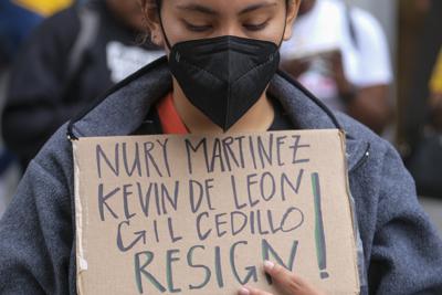 Un manifestante sostiene una pancarta fuera del Ayuntamiento de Los Ángeles, el martes 11 de octubre de 2022, durante una sesión del Concejo Municipal de Los Ángeles. (AP Foto/Ringo H.W. Chiu)
