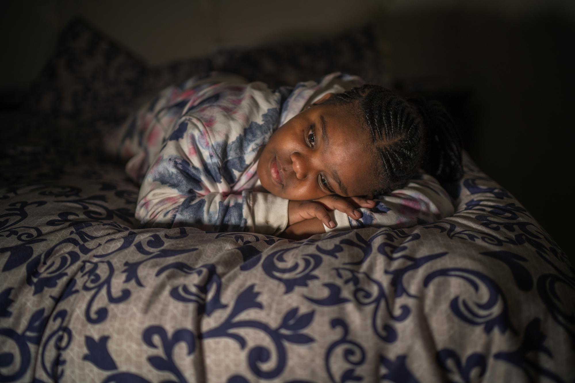 Tshimologo Bonolo, 8, poses for a photograph at her house in Soweto, South Africa, Saturday, June 26, 2021. She lost her father to COVID-19 in July 2020, and is now looked after by her mother and her grandmother. (AP Photo/Jerome Delay)