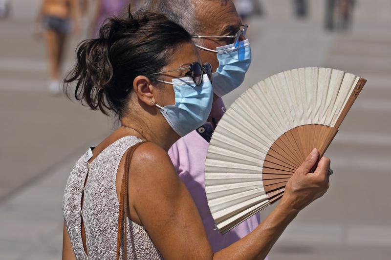 A woman fans herself in Madrid, Spain, Tuesday, Aug. 10, 2021. Temperatures are beginning to rise at the start of an oncoming heatwave in Spain which will last up until the weekend with temperatures expected to reach over 40 degrees Celsius (104 degrees fahrenheit) in Madrid and southern Spain. (AP Photo/Paul White)