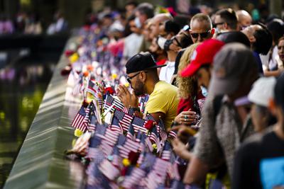 Varias personas llegan al Memorial y Museo del 11 de septiembre, en Nueva York, luego de las ceremonias para conmemorar el 20mo aniversario de los atentados, el 11 de septiembre de 2021. (AP Foto/Matt Rourke)