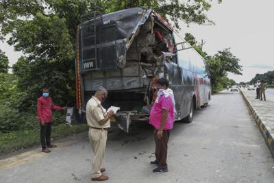 Un agente de policía toma notas frente a un autobús estacionado que fue impactado por un camión durante a noche en Barabanki, en el estado de Uttar Pradesh, la India, el miércoles 28 de julio de 2021. (AP Foto/Sumit Kumar)