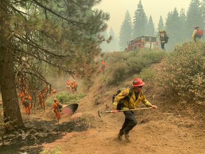 Bomberos de CalFire y reclusos del Centro Correccional de California (CCC) combaten un incendio a un costado de la carretera CA-36 entre Chester y Westwood en el condado Plumas, California. (AP Foto/Eugene Garcia)