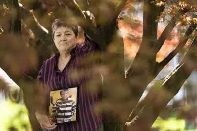 Georgene White posa para un retrato con una foto de su madre, Teri Sheridan, en Belvidere, Nueva Jersey, el jueves 20 de abril de 2023. A los 93 años, luchando con los efectos de un derrame cerebral, insuficiencia cardíaca y cáncer recurrente, Sheridan estaba lista para terminar con su vida usando la ley de Nueva Jersey que permite el suicidio médicamente asistido, pero estaba postrada en cama, demasiado enferma para viajar. Así que el 17 de noviembre de 2022, rodeada de tres de sus hijos, Sheridan bebió una dosis letal de medicamentos recetados por un médico que nunca había conocido en persona, solo en línea. Murió en cuestión de minutos. (AP Photo/Matt Rourke)