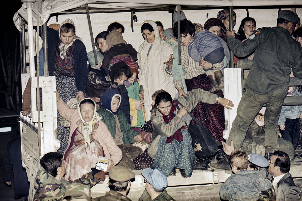 FILE- In this March 20, 1993, file picture evacuees form the besieged Bosnian town of Srebrenica jump off a U.N. truck after arriving in Tuzla, after a tense journey across the most contested battle lines in Bosnia. Survivors of the genocide in the eastern Bosnian town of Srebrenica, mainly women, will on Saturday July 11, 2020, commemorate the 25th anniversary of the slaughter of their fathers and brothers, husbands and sons. At least 8,000 mostly Muslim men and boys were chased through woods in and around Srebrenica by Serb troops in what is considered the worst carnage of civilians in Europe since World War II. The slaughter was also the only atrocity of the brutal war that has been confirmed an act of genocide.(AP Photo/Michel Euler, File)