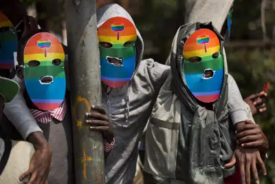ARCHIVO - Gays y lesbianas de Kenia y otras personas que apoyan su causa llevan máscaras para preservar su anonimato mientras realizan una protesta inusual, contra la dura postura de Uganda contra la homosexualidad y en solidaridad con sus homólogos de ese país, frente a la Alta Comisión de Uganda en Nairobi, Kenia, 10 de febrero de 2014. (AP Foto/Ben Curtis, Archivo)