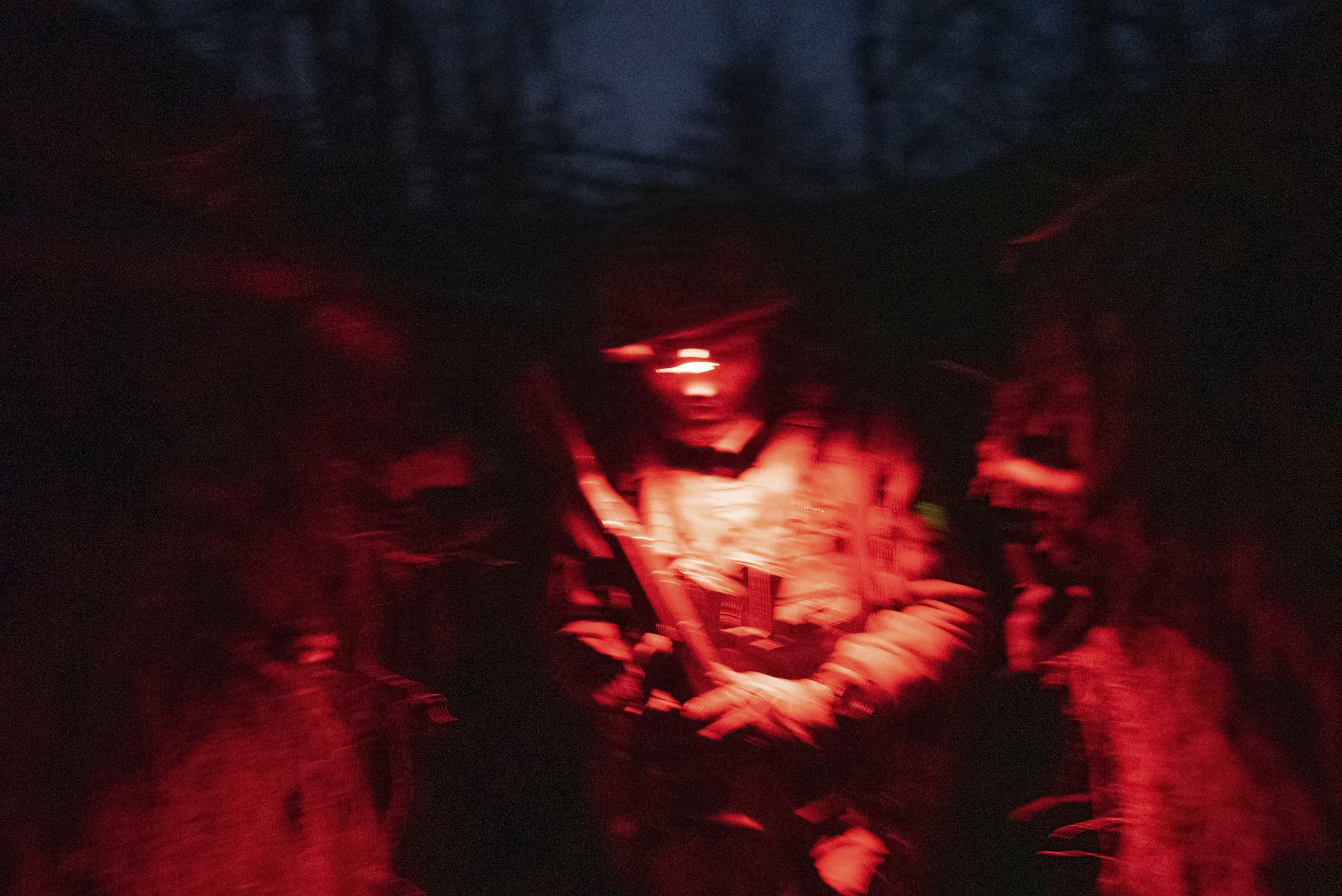 FILE - A Ukrainian serviceman walks along a trench on a position at the line of separation between Ukraine-held territory and rebel-held territory near Zolote, Ukraine, late Feb. 19, 2022. (AP Photo/Evgeniy Maloletka)