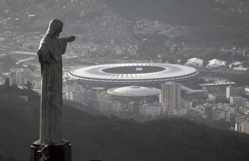 ARCHIVO - En esta foto del 13 de mayo de 2014, vista del estadio Maracaná detrás del Cristo Redentor en Río de Janeiro. Brasil será la sede de la Copa América por segunda edición seguida. (AP Foto/Felipe Dana, archivo)