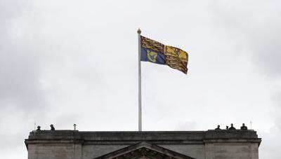 Agentes de policía observan desde el tejado del Palacio de Buckingham antes de que la reina Isabel II salga de palacio para la sesión de apertura del Parlamento en la Cámara de los Lores, en Londres, el martes 11 de mayo de 2021. (AP foto/Alastair Grant)