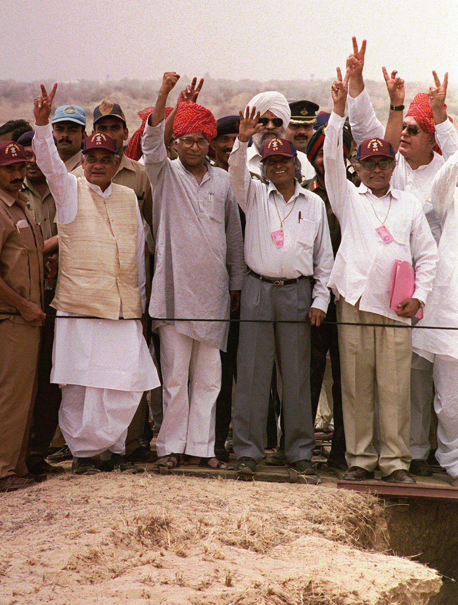 ARQUIVO - O primeiro-ministro indiano Atal Bihari Vajpayee, segunda à esquerda, o ministro da Defesa George Fernandes, ao centro, fundador do programa nuclear indiano APJ Abdul Kalam, à direita, e o chefe de energia atômica R. Chidambaram exibem o símbolo da vitória durante uma visita ao Shakti 1 local de teste, onde a Índia testou dispositivos nucleares uma semana antes, em Pokhran, Índia, 20 de maio de 1998. (AP Photo/Ajit Kumar, Arquivo)