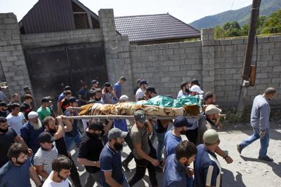 ARCHIVO - Gente cargando el cuerpo de una víctima de asesinato identificada como Zelimkhan Khangoshvili, un georgiano musulmán, en su funeral en el poblado de Duisi, en el valle de la Garganta del Pankisi, en Georgia, el 29 de agosto de 2019.  (AP Foto/Zurab Tsertsvadze, archivo)