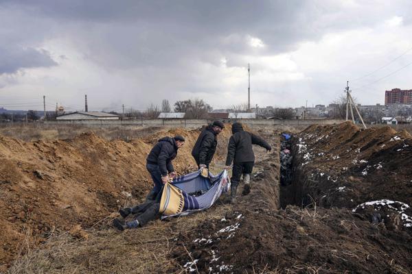 Los cadáveres son colocados en una fosa común en las afueras de Mariupol, Ucrania, el miércoles 9 de marzo de 2022, ya que las personas no pueden enterrar a sus seres queridos debido a los fuertes bombardeos de las fuerzas rusas. (AP Foto/Evgeniy Maloletka)