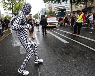 People take part in the "Rave the Planet" parade in Berlin, Saturday, July 9, 2022. A techno parade whose initiators include the founder of Berlin's once-popular Love Parade has started in the streets of the German capital with calls for the city’s electronic music culture to be added to a world heritage list. The “Rave the Planet” parade set out on Saturday in cool, rainy weather. (Paul Zinken/dpa via AP)