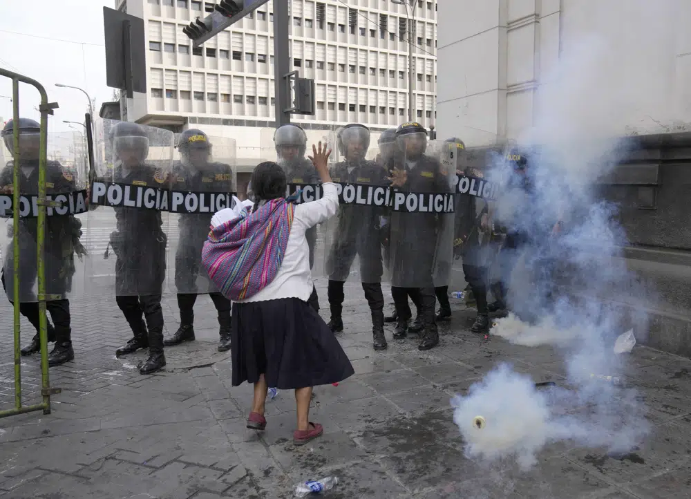 Una mujer, que es parte de los manifestantes opositores que viajaron a la capital desde otras partes del país para marchar contra la presidenta peruana Dina Boluarte, intenta hacer retroceder a la policía con una oración y una Biblia durante los enfrentamientos en Lima, Perú, el jueves 19 de enero de 2023. Las protestas buscan un adelanto electoral inmediato, la renuncia de Boluarte, la liberación del presidente destituido Pedro Castillo y justicia por los al menos 48 manifestantes muertos en enfrentamientos con la policía. (AP Foto/Martín Mejía)