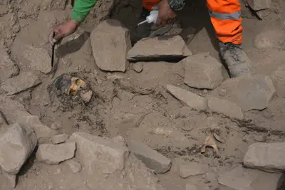 Un arqueólogo excava en la tumba de una momia prehispánica descubierta en una cima cercana a un campo de fútbol de un popular club peruano en el barrio de El Rimac de Lima, Perú, el jueves 15 de junio de 2023. (AP Foto/Martín Mejía)