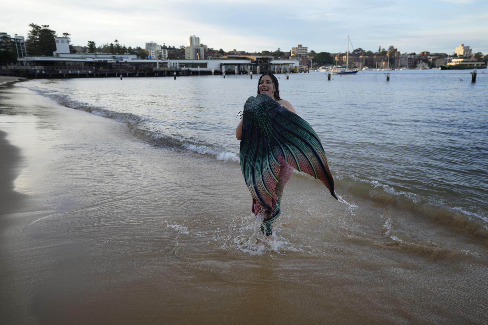 Lauren Metzler, founder of Sydney Mermaids, walks from the water at Manly Cove Beach in Sydney, Australia, Thursday, May 26, 2022. (AP Photo/Mark Baker)