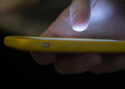 Un hombre usa un teléfono celular en Nueva Orleans el 11 de agosto de 2019. (AP Foto/Jenny Kane, File)