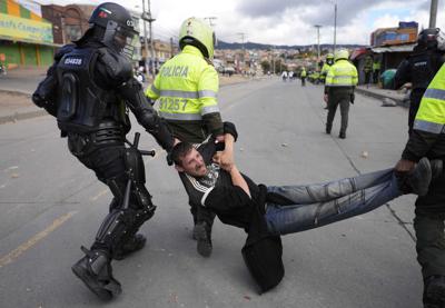 La policía detiene a un hombre durante una protesta contra el aumento de impuestos propuesto sobre los servicios públicos, el combustible, los salarios y las pensiones en Bogotá, Colombia, el lunes 28 de junio de 2021. (AP Foto/Fernando Vergara)