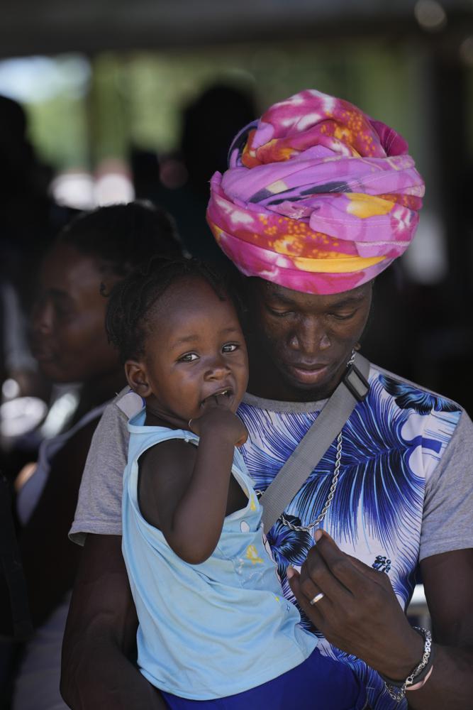 Migrantes, muchos de ellos de Haití, hacen fila para abordar un autobús que los trasladará a otro refugio en su viaje por Panamá, tratando de llegar a Estados Unidos, en Lajas Blancas, provincia de Darién, Panamá, el viernes 1 de octubre de 2021. (Foto AP/Arnulfo Franco)