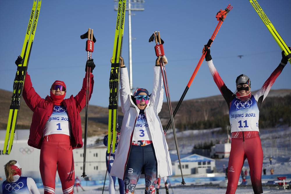 From left, silver medal finisher Russian athlete Natalia Nepryaeva, gold medal finisher Norway's Therese Johaug and bronze medal finisher Austria's Teresa Stadlober celebrate after the women's 7.5km + 7.5km skiathlon cross-country skiing competition at the 2022 Winter Olympics, Saturday, Feb. 5, 2022, in Zhangjiakou, China. (AP Photo/Aaron Favila)