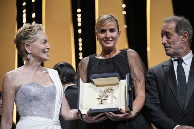 La directora Julia Ducournau, en el centro, posa con Sharon Stone y Vincent Lindon tras ganar la Palma de Oro por la película "Titane" en la ceremonia de clausura del Festival Internacional de Cine de Cannes, el sábado 17 de julio de 2021 en Cannes, Francia. (AP Foto/Vadim Ghirda)