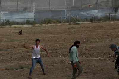 Manifestantes lanzan piedras a tropas israelíes cerca de la frontera de la Franja de Gaza con Israel, en una protesta por el aniversario de un incendio provocado en 1969 contra la mezquita de Al-Aqsa, en Jerusalén, obra de un turista australiano con una enfermedad mental, en el este de Ciudad de Gaza, el sábado 21 de agosto de 2021. (AP Foto/Adel Hana)