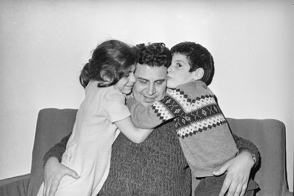 FILE - In this Jan. 27, 1968 file photo, Greek composer Mikis Theodorakis is hugged by his children, Margarita, left, and Giorgios, after his release from prison in Athens, Greece. Mikis Theodorakis, the beloved Greek composer whose rousing music and life of political defiance won acclaim abroad and inspired millions at home, died on Thursday, Sept. 2, 2021. He was 96. (AP Photo/File)