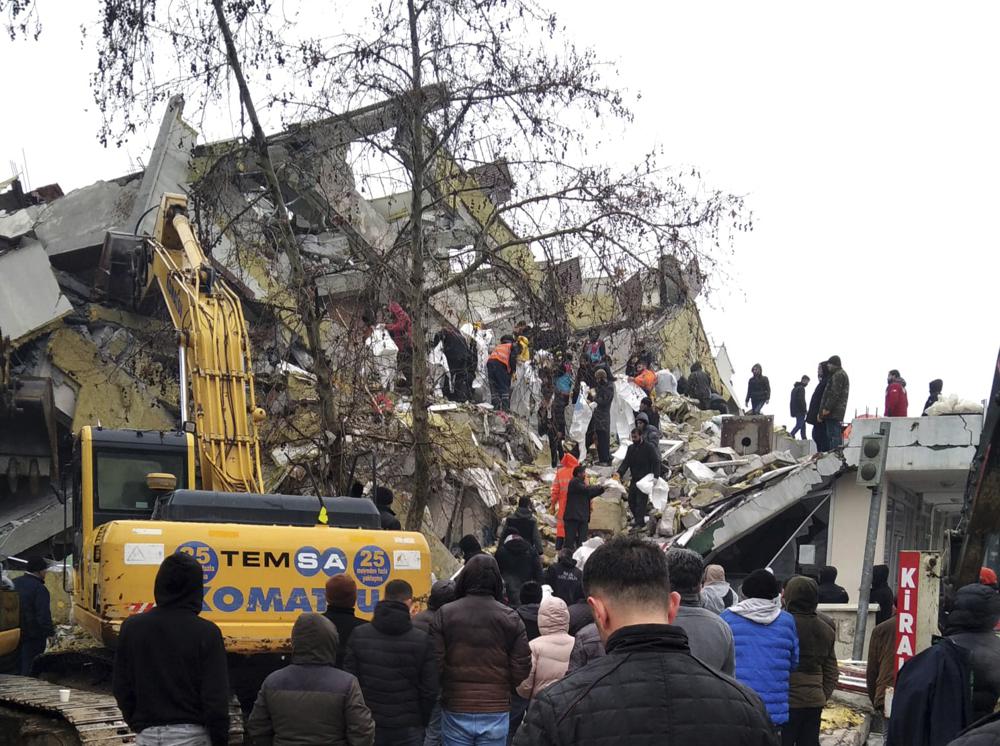 Rescue workers try to reach trapped residents in a collapsed building in Kahta, in Adiyaman province, southeastern Turkey, Monday, Feb. 6, 2023. A powerful earthquake that struck southeast Turkey and northern Syria has killed more than 640 people with hundreds injured. The toll is expected to rise as rescuers search for dead and survivors in dozens of collapsed buildings across the region. (AP Photo)