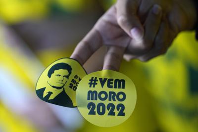 ARCHIVO - Un partidario sostiene pegatinas relacionadas con la campaña presidencial del exjuez federal Sergio Moro en Brasilia, el 10 de noviembre de 2021. "#vamos moro 2022" decían las pegatinas. (AP Foto/Eraldo Peres, Archivo)