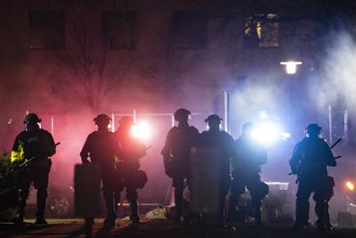 ARCHIVO _  En esta foto del 14 de abril del 2021, policías despejan un área de manifestantes durante una protesta por la muerte a tiros de Daunte Wright en una parada de tráfico, en las afueras del departamento de policía de Brooklyn Center, Minnesota. Las agencias del orden en Estados Unidos registraron una ola de retiros y salidas y están pasando trabajo para reclutar una nueva generación de policías en el año desde que George Floyd fue asesinado por un policía. (AP Foto/John Minchillo, archivo)