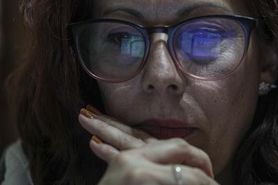 La pantalla de la computadora se refleja en las gafas de la profesora de ciencias Marcela García mientras enseña de forma remota desde su casa debido a que las clases presenciales están suspendidas por la pandemia de COVID-19 en Santiago de Chile, el miércoles 30 de junio de 2021. (AP Foto/Esteban Felix)