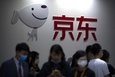 Visitantes pasan frente a un puesto del comerciante minorista online chino JD. com en la Feria Internacional de Comercio de Servicios en Beijing, 3 de septiembre de 2021. JD.com Inc., el mayor comerciante minorista online de China, y la empresa canadiense de servicios al comercio Shopify lanzaron un emprendimiento el martes 18 de enero de 2022 para dar a los comerciantes estadounidenses mayor acceso a los 550 millones de clientes de JD.com. (AP Foto/Mark Schiefelbein)