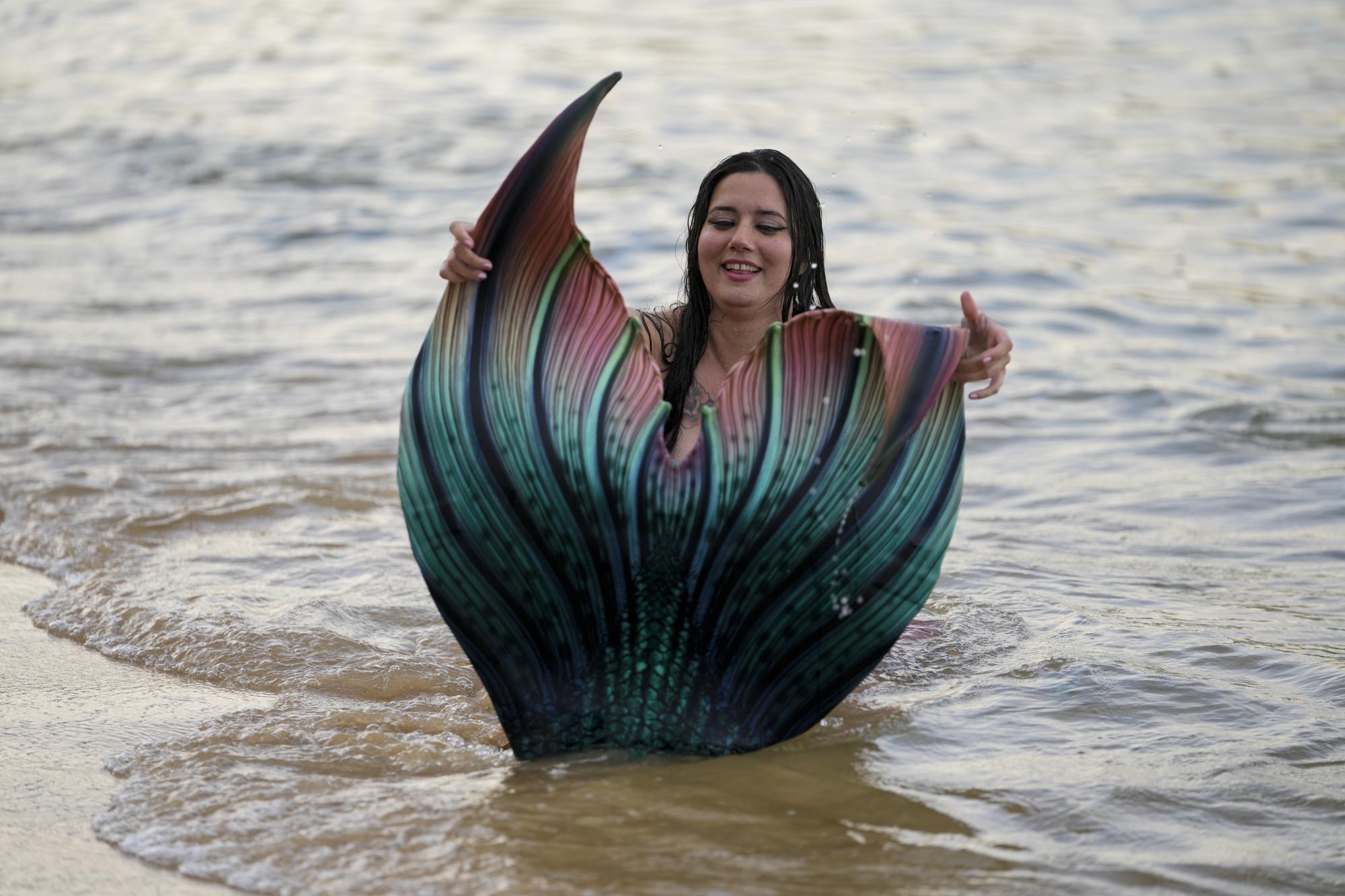 Lauren Metzler, founder of Sydney Mermaids, prepares for a swim at Manly Cove Beach in Sydney, Australia, Thursday, May 26, 2022. Metzler received her advanced mermaid certification this month with a goal of teaching rookie merfolk how to avoid sinking to the seabed. (AP Photo/Mark Baker)