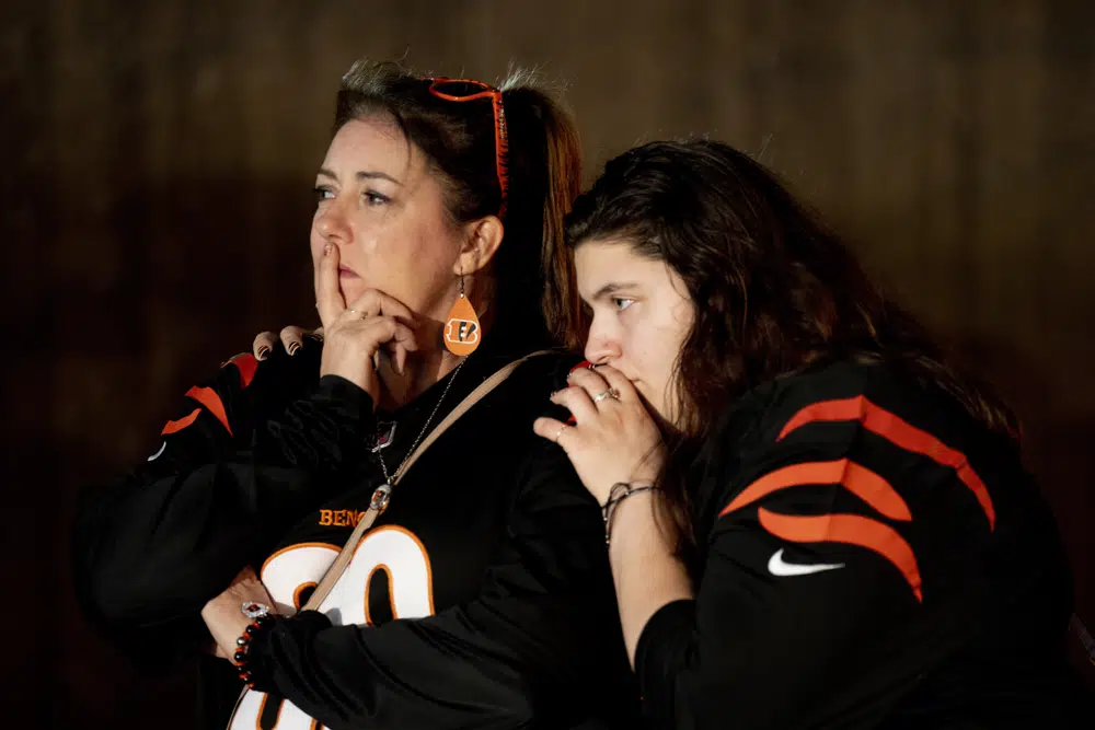 Heather Rohr, of Montfort Heights, and Anna Britt, of Groesbeck, stand outside the University of Cincinnati Medical Center where Buffalo Bills safety Damar Hamlin was taken after collapsing during an NFL football game against the Cincinnati Bengals in Cincinnati on Monday, Jan. 2, 2023. (Albert Cesare/The Cincinnati Enquirer via AP)