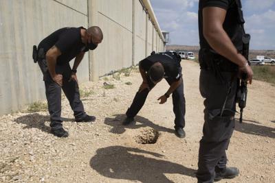 Policías y guardias inspeccionan el lugar donde se efectuó una fuga en la prisión de Gilboa, en el norte de Israel, el lunes 6 de septiembre de 2021. (AP Foto/Sebastian Scheiner)