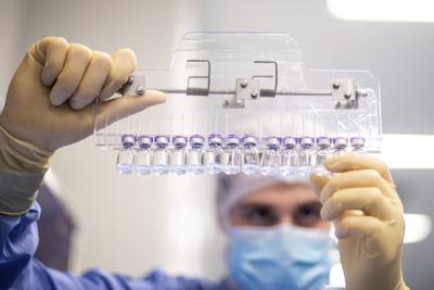 ARCHIVO - En esta foto de marzo del 2021 proveída por Pfizer, un técnico de laboratorio inspecciona viales llenos de la vacuna para el COVID-19 en las instalaciones de la compañía en Puurs, Bélgica.  (Pfizer vía AP)