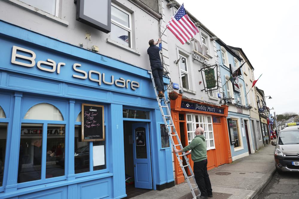 Los publicanos colocaron banderas estadounidenses frente al bar Blue Square en Ballina, Irlanda, el martes 4 de abril de 2023. La emoción crece en Ballina, una pequeña ciudad irlandesa que fue hogar de algunos de los antepasados ​​del presidente Joe Biden.  Biden tiene previsto visitar la ciudad la próxima semana, como parte de un viaje de cuatro días a Irlanda y la vecina Irlanda del Norte. (AP Photo/Peter Morrison)