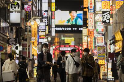 ARCHIVO - En esta imagen de archivo del 1 de octubre de 2021, gente caminando por el famoso distrito de ocio de Kabukicho, en Tokio, en la primera noche después de que el gobierno levantara el estado de emergencia por coronavirus. (AP Foto/Hiro Komae, Archivo)