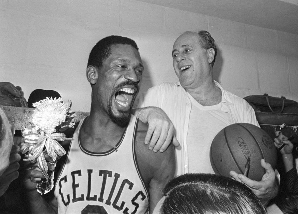 FILE - Boston Celtics' Bill Russell, left, holds a corsage sent to the dressing room as he celebrates with Celtics coach Red Auerbach after defeating the Los Angeles Lakers, 95-93, to win their eighth-straight NBA Championship, in Boston, in this April 29, 1966, photo. The NBA great Bill Russell has died at age 88. His family said on social media that Russell died on Sunday, July 31, 2022. Russell anchored a Boston Celtics dynasty that won 11 titles in 13 years. (AP Photo/File)